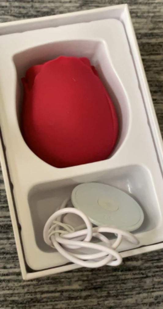 Red rose toy in its white box tray with the charging cable and dock