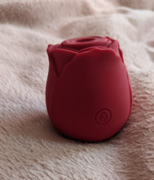 Dark red rose toy standing on a soft blanket, showing the smooth silicone body