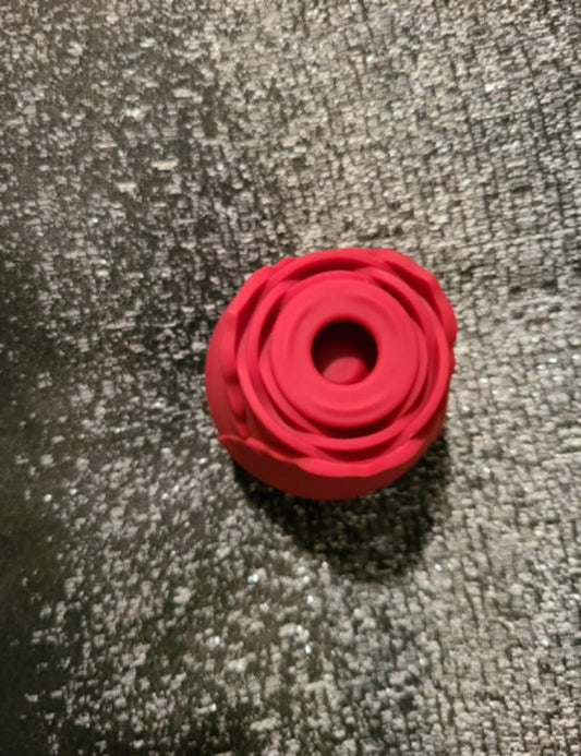 Top view of a red rose toy showing the suction opening in the center of the petals