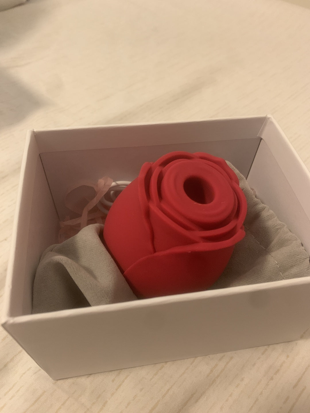 Rose toy unboxed: red rose suction toy in its white box with storage pouch and charging cable